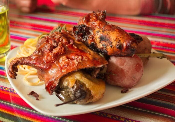 Cuy al horno, traditional Andean dish Cuy al horno served with Andean potatoes, a traditional dish from Cusco, Peru