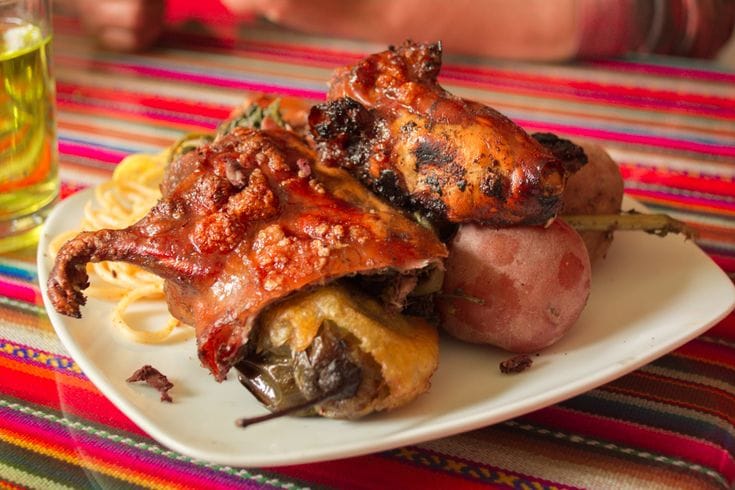 Cuy al horno tradicional andino Cuy al horno servido con papas andinas, plato tradicional de Cusco, Peru